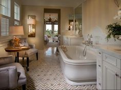 a bathroom with a tub, sink and chair in it