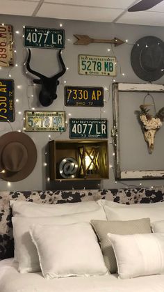 a bed room with a neatly made bed and lots of license plates on the wall