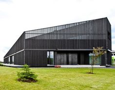 a large black building sitting on top of a lush green field