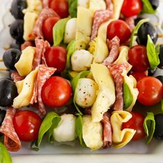 a close up of a plate of food with meat and veggies on skewers