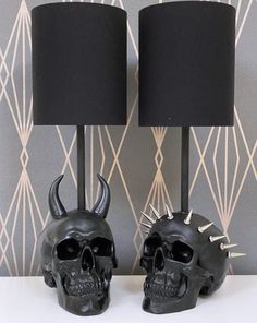 two black skull lamps with spikes on them