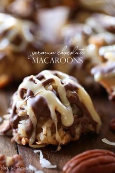 chocolate covered macaroons with white icing drizzled on top and pecans scattered around