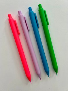 four different colored pens sitting next to each other