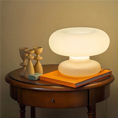 a lamp sitting on top of a table next to a book