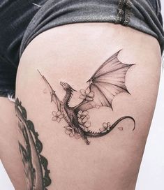 a woman's thigh with a dragon tattoo on it