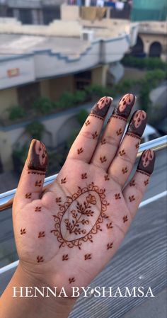 henna on the palm of a woman's hand with flowers and hearts painted on it