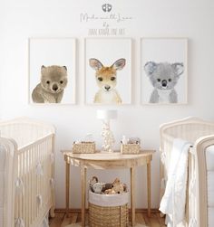 there are three pictures on the wall in this baby's room, one is an animal