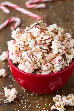 a red bowl filled with peppermin bark popcorn