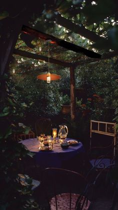 an outdoor dining area with blue table cloths and chairs, surrounded by greenery