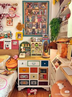 a child's bedroom with lots of toys on the desk and shelves above it