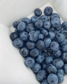 blueberries are in a white bowl on the table