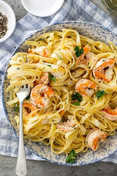 a bowl filled with pasta and shrimp on top of a table