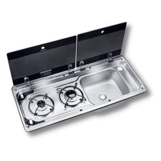 two burners in the middle of a double sink with an open door on one side