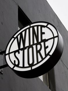 a wine store sign hanging from the side of a building