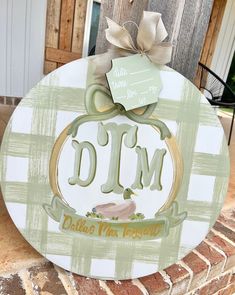 a wooden sign that says d m with a bow on it's head and the word d m written in gold