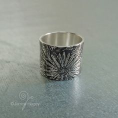 This wide band ring made from recycled sterling silver features my abstract asters pattern in a full 5/8" (16mm) wide ring shown here. It can also be made in 1/2" (13mm) width if requested from the drop down menu when ordering. Size 7 1/2 is currently in stock. Because these are one-of-a-kind, it will be slightly different than the picture, but each one will have the larger focal aster, which was originally created by hand from a scratchboard drawing. Please allow 1 to 2 weeks for fabrication. Scratchboard Drawing, Scratchboard Drawings, Wide Band Ring, Wide Ring, Wide Rings, Wide Band Rings, Recycled Sterling Silver, Wide Bands, Band Ring