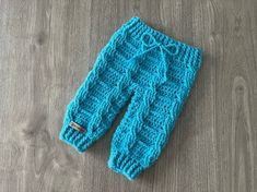 a blue knitted leggings laying on top of a wooden floor