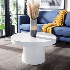 a living room with a blue couch and white table