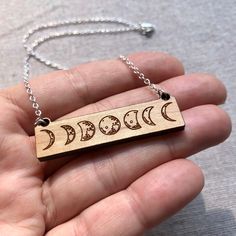 "New design in my shop! Laser cut wood moon phases bar necklace, This pendant is wooden, rectangle shape with moon phases. Suspended on a delicate sterling silver chain and finished with a lobster clasp. Also offered in a vertical pendant in a separate listing in my shop. Moon phase bar necklace 2\" wide rectangle pendant Sterling silver chain. Your choice of length. Coordinating earrings shown in last photo." Glowforge Necklace, Laser Engraved Jewelry, Celestial Brass Necklace With Moon Phase, Metal Moon Phase Necklace, Moon Phase Necklace In Metal, Moon Phase Brass Pendant Necklace, Funny Necklace, Laser Cut Wood Jewelry, Laser Cut Wood Pendant Necklace