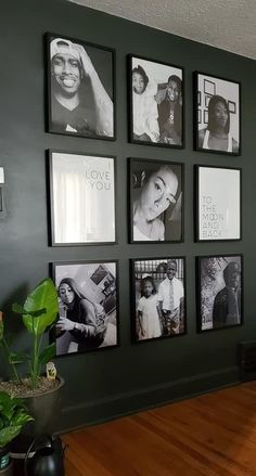 black and white photos are hung on the wall in a room with wood floors, green walls