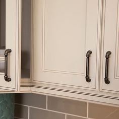 a kitchen with white cabinets and green marble counter tops on the backsplash is shown