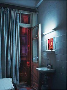 a bathroom with a sink, mirror and shower stall in the corner next to a window