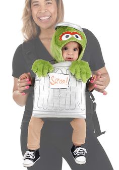 a woman holding a baby dressed as kermie from the muppets costume