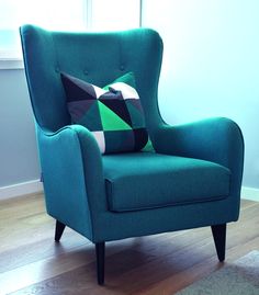 a green chair with a pillow on top of it