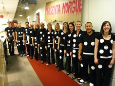 a group of people that are standing in front of a red carpet with polka dots on them