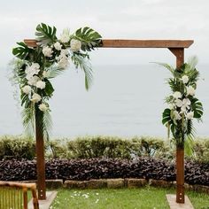 an outdoor ceremony setup with white flowers and greenery