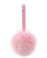 a pink pom - pom keychain hanging on a white wall