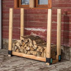 a pile of wood sitting in front of a red brick building next to a window