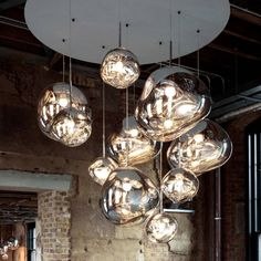 a large chandelier hanging from the ceiling in a room with exposed brick walls