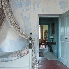 a bed sitting in the middle of a bedroom next to a doorway with curtains on it