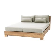 a bed with two pillows on top of it and a wooden frame around the headboard