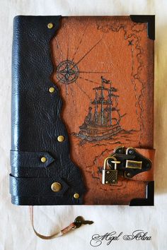 an old book with a ship drawn on it and a key attached to the cover