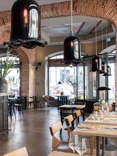 an empty restaurant with tables and chairs in front of large windows, hanging from the ceiling