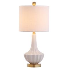 a white lamp with a gold base on a white background and a light shade over it