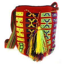 a colorful bag with tassels and fringe on the front, sitting on a white surface