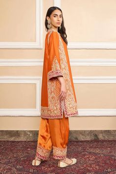 Orange pure silk chanderi A-line kurta with gota applique and kashmiri tilla embroidery. Comes with bamberg satin salwar and a silk organza dupatta with kinari finish.
Component: 3
Pattern: Embroidered
Type Of Work: Gota applique, Kashmiri tilla
Neckline: Band collar
Sleeve Type: Three quarter
Fabric: Kurta : Pure silk chanderi, Salwar : Bamberg satin, Dupatta : Silk organza
Color: Orange
Other Details: 
Short slits
Embroidered border at hem
Buttoned placket
Occasion: Mehendi and Haldi, Sangeet Kashmiri Tilla Embroidery, Satin Salwar, Satin Dupatta, Tilla Embroidery, A Line Kurta, Embroidered Border, Organza Dupatta, Silk Organza, Band Collar