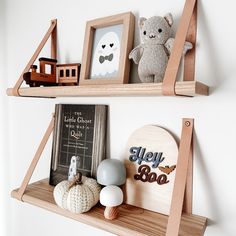 two wooden shelves with pictures and toys on them, one shelf has a teddy bear