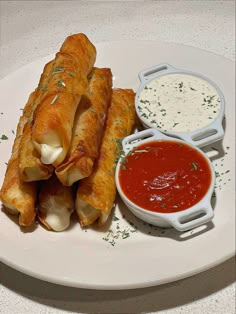 a white plate topped with food and dipping sauce