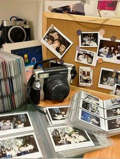 a table topped with photos and pictures next to a wooden box filled with cd's