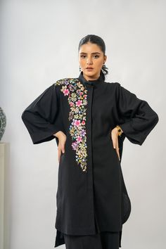 Noir Garland co-ord set made in Premium Irish Cotton with beautiful floral embroidery on shoulder, body and back. Stay graceful and fashionable in colder months with this cozy outfit.   -Premium Irish Cotton  -Loose fit buttoned down oversized shirt  -Dropped shoulder sleeves  -Intricate Hand-Machine Embroidery on shoulder, body and back -Cropped lose pants -Adjustable pant with elastic at back for comfort  -Hanging loop for your ease  -Hand wash only Festive Cotton Sets With Embroidered Sleeves, Eid Long Sleeve Sets With Embroidered Cuffs, Spring Sets With Embroidered Long Sleeves, Elegant Cotton Sets With Embroidered Cuffs, Fitted Sets With Embroidered Cuffs For Festive Occasions, Elegant Embroidered Top For Eid, Spring Cotton Sets With Embroidered Sleeves, Long Sleeve Cotton Dress With Embroidery, Festive Cotton Formal Top