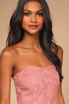 a woman in a pink dress posing for the camera