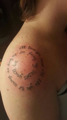 the back of a woman's shoulder with words written in cursive writing