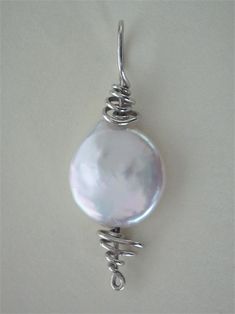 Cultured Freshwater Pearl Coin Bead Pendant Wire Wrapped in .925 Sterling Silver Round Wire This refreshing and enlightening cultured freshwater pearl coin bead displays a fine fluid iridescent sheen. Versatile, it wears well with almost any color of clothing, including both gray and brown based color tones. It gives a sharp contrast to darker colors and a pleasant blend to lighter/pastel colors. It is also a nice match with most earth tone colors. Consistent color and near round shape give some Earth Tone Colors, Beaded Wraps, Pearl Size, Beaded Pendant, Pearl Pendant, Silver Wire, Colour Tone, Pearl Beads, Base Colour