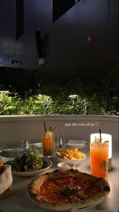 a table topped with pizza and drinks on top of it