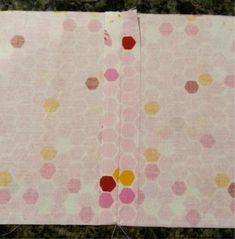 two pieces of pink fabric with yellow and red dots on them are laying next to each other