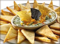 tortilla chips with salsa and cheese in a white bowl on a platter